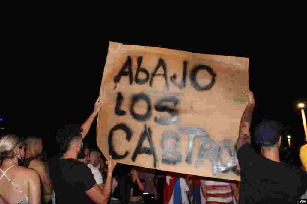 Exiliados portan un cartel contra el gobierno comunista de Cuba, en manifestación en la Calle 8 en Miami, Florida, en apoyo a las protestas sucedidas en la isla el domingo 11 de julio de 2021. Foto: Luis F. Rojas, VOA.