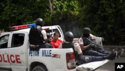 La policía en Puerto Príncipe, capital de Haití, traslada en una camioneta a dos presuntos participantes en el asesinato del presidente Jovenel Moise el 7 de julio de 2021.