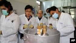 IAEA 관계자들과 이란 기술자들이 지난 2014년 이란 테헤란 남쪽 나탄즈 핵 시설에서 고농축 우라늄 생산용 원심분리기 작동을 중단시키고 있다.