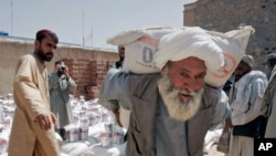 Pada foto yang diambil 10 Mei, 2009, tampak seorang pria memikul sekarung gandum yang didistribusikan oleh Badan Pangan PBB WFP untuk warga miskin di Kandahar, Afghanistan. (Foto:AP/Allauddin Khan)