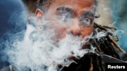 资料照片：一名示威者吸着电子烟参加在麻萨诸塞州州议会的抗议活动，反对该州在波士顿对所有电子烟产品施行的历时四个月禁售令。(2019年10月3日)