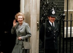 FILE - Britain's Prime Minister Margaret Thatcher waves to members of the media on returning to No. 10 Downing Street from Buckingham Palace after a visit with Queen Elizabeth II, May 11, 1987.