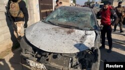 Las fuerzas de seguridad inspeccionan un automóvil dañado en el lugar de un ataque aéreo estadounidense en al-Qaim, Irak, el 3 de febrero de 2024.