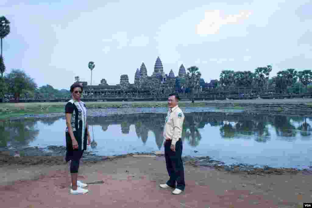 មគ្គុទ្ទេសក៍ទេសចរណ៍បង្ហាញដល់លោកស្រី Michelle Obama ក្នុងពេលដើរទស្សនានៅបរិវេណប្រាសាទអង្គរវត្ត នៅរសៀលថ្ងៃសៅរ៍ ទី២១ ខែមីនា ឆ្នាំ២០១៥។