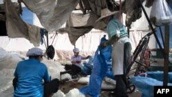 Myanmar migrant and Thai workers drying polyester materials in a textile factory 
