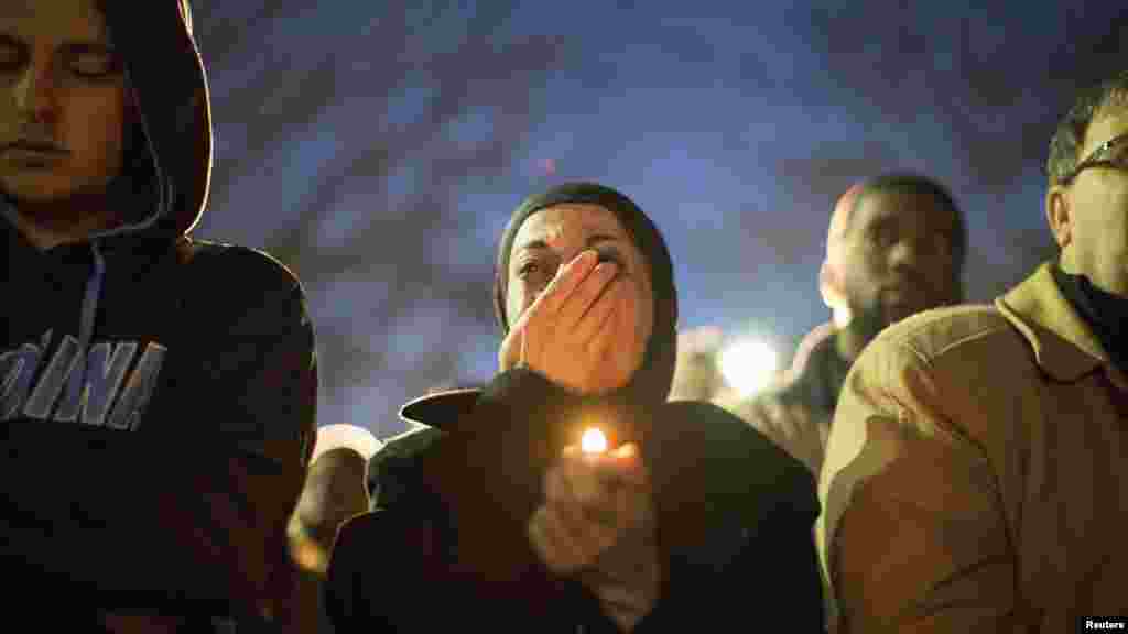 A woman cries as a video is played during a vigil on the campus of the University of North Carolina for three young Muslims slain in Chapel Hill, N.C., Feb. 11, 2015.