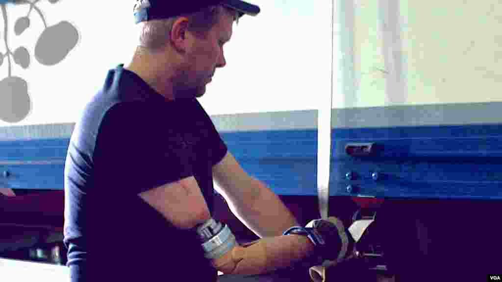 Cet homme porte une prothèse de bras directement connectée à ses os, nerfs et muscles, au travail, dans un lieu non déterminé. (courtesy, Sci. Trans. Med., 2014)