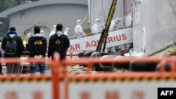 台湾中央流行疫情指挥中心工作人员身穿防护服登上基隆港的宝瓶星号游轮。（2020年2月8日）