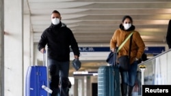 Pasajeros usando mascarillas llegan al Aeropuerto Charles de Gaulle, en París.El tráfico aéreo se ha visto afectado por el temor al contagio del coronavirus, generando enormes pérdidas a las aerolíneas.