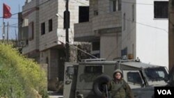 Tentara Israel berpatroli di perkampungan Awarta, Sabtu (12/3) setelah sebuah keluarga dibunuh di dekat Itamar, salah satu pemukiman Yahudi di Tepi Barat.
