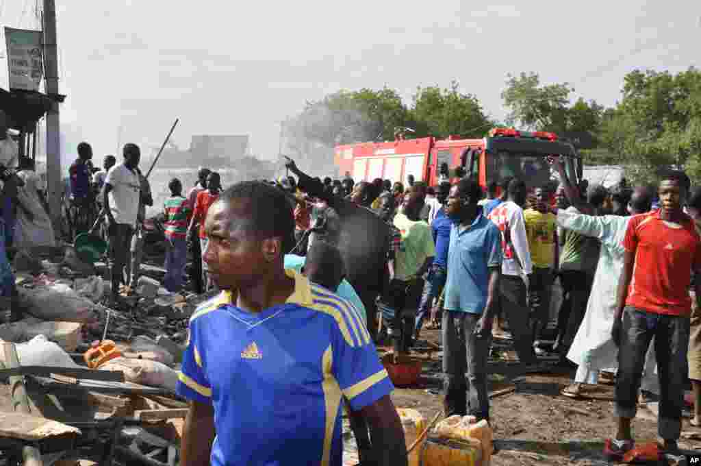 Mutane sun taru kusa da inda bam ya tashi cikin mota a kasuwar "Monday Market" ta Maiduguri, talata 1 Yuli, 2014. Mutane da dama sun mutu, akasarinsu mata tsoffi da almajirai dake bara.