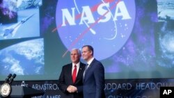 Vice President Mike Pence, left, shakes hands with the new NASA administrator Jim Bridenstine, right, on stage during a swearing-in ceremony, April 23, 2018, at NASA Headquarters in Washington.