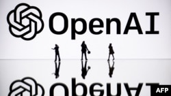 FILE - This illustration photograph taken on October 30, 2023, in Mulhouse, eastern France, shows figurines next to a screen displaying a logo of OpenAI. (Photo by SEBASTIEN BOZON / AFP)