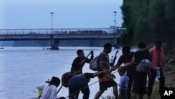 Migrantes venezolanos llegan al lado mexicano de la frontera después de navegar en balsa por el río Suchiate, la frontera entre Guatemala y México, cerca de Ciudad Hidalgo, estado de Chiapas, México, el martes 4 de octubre de 2022. (Foto AP/Marco Ugarte)