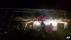 ARCHIVO - En esta fotografía publicada por la Policía Boliviana de Oruro, los bomberos trabajan para rescatar a los pasajeros después de que un autobús chocó de frente con un camión volquete, en las afueras de Machamarca, Bolivia, el lunes 18 de febrero de 2019.