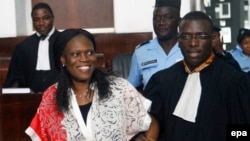 L’ancienne première dame de la Côte-d'Ivoire, Simone Gbagbo, à gauche, est accompagnée de son avocat, au premier jour de son procès à la Cour Abidjan Justice, Côte-d'Ivoire, 31 mai 2016.