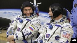 El astronauta estadounidense Nick Hague (derecha) y el cosmonauta ruso Alexey Ovchinin hablan antes de despegar a bordo de una cápsula Soyuz MS-10 hacia la Estación Espacial Internacional, en Baikonur, Kazajistán, el 11 de octubre de 2018. (AP Foto/Dmitri Lovetsky) 