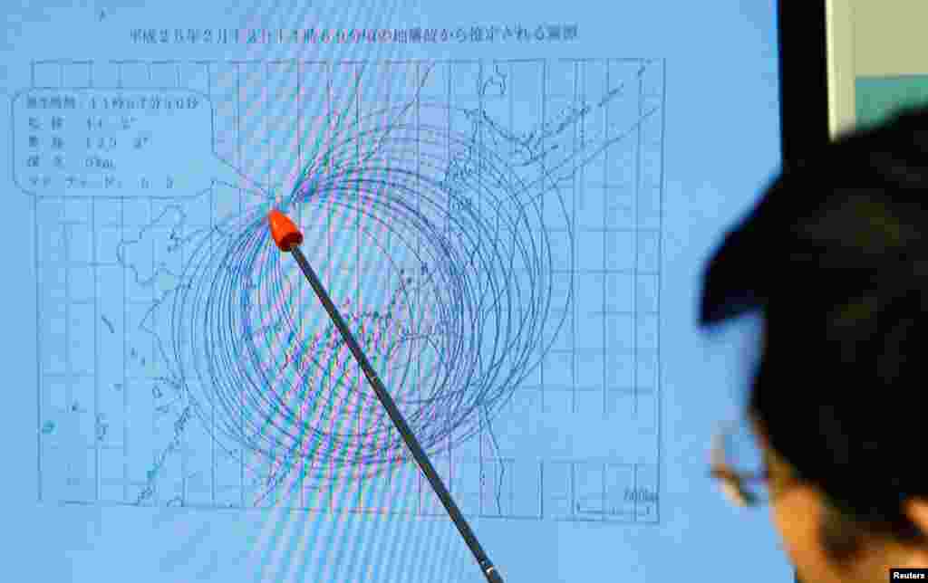 Japan Meteorological Agency's earthquake and tsunami observations division director Akira Nagai points to a spot on the map showing the quake center during a news conference in Tokyo, February 12, 2013.