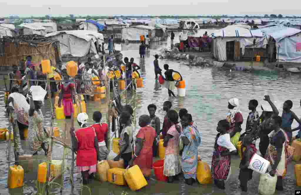 Des déplacées Sud Soudanaises font la queue dans une eau d’inondation atteignant les genoux avant d’accéder à l’eau potable provenant d'un forage, à un camp de fortune pour personnes déplacées situé dans la Mission des Nations Unies au Soudan du Sud (MINUSS) dans le village de Bentiu, au Soudan du Sud le lundi 22 septembre 2014.