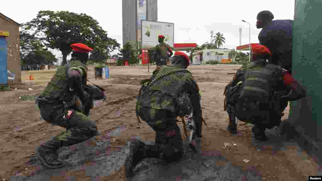Des agent des forces de l'ordre prennent position, arme à la main et prête à être utilisée, lors d'une émeute à Kinshasa prêt de la télévision nationale congolaise, le 30 décembre 2013. REUTERS/Jean Robert N'Kengo.