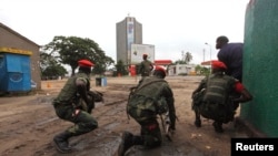 Des officiers congolais sont en position près du siège d'une télévision à Kinshasa, en RDC, le 30 décembre 2013.
