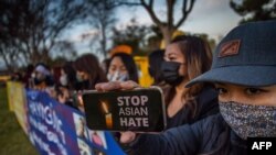 Julie Tran holds her phone during a candlelight vigil in Garden Grove, California, March 17, 2021 to unite against spate of violence targeting Asians after the shooting that left eight people dead in Atlanta, Georgia, including at least six Asian women.