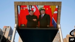 北京街头大屏幕播放习近平为金正恩举行欢迎仪式的画面