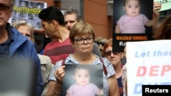 Aktivis memegang poster dan meneriakkan slogan-slogan ketika unjuk rasa di luar kantor Departemen Imigrasi Australia di Sydney, 4 Februari 2016. 