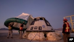 Boeing, NASA, and U.S. Army personnel work around the Boeing Starliner spacecraft shortly after it landed in White Sands, N.M., Sunday, Dec. 22, 2019. Boeing safely landed its crew capsule in the New Mexico desert Sunday after an aborted flight to…