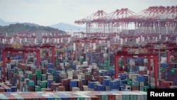 FILE - Containers are ready at the Yangshan Deep-Water Port in Shanghai, China, on Oct. 19, 2020. China's exports fell by 14.5% in July 2023 compared with a year earlier.