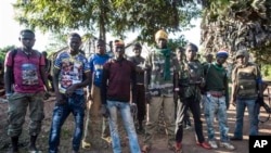 In this Aug. 28, 2014, photo an Anti-Balaka group that defends the Christian neighborhood near the Church of the city stands for a photo in Boda, Central African Republic. More than 5,000 people have died in sectarian violence in the Central African Republic since December, according to an Associated Press tally. (AP Photo/Sylvain Cherkaoui)
