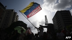 ARCHIVO - Un partidario del presidente y candidato presidencial venezolano Nicolás Maduro ondea una bandera venezolana durante una manifestación en Caracas el 4 de julio de 2024.