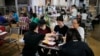 Para imigran China yang dideportasi dari Amerika, makan di food court stasiun bus setelah tiba di Panama City, Sabtu, 8 Maret 2025.