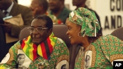 President Robert left listens to his wife Grace, right, at the 9th Zanu PF National Peoples Conference in Goromonzi, 45 km east of Harare, Friday, Dec, 15, 2006. (AP Photo/Tsvangirayi Mukwazhi)