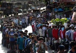 Migrant workers line up to board buses for their onward journey by train to their home states, at Dharavi, one of Asia's largest slums, in Mumbai, India.
