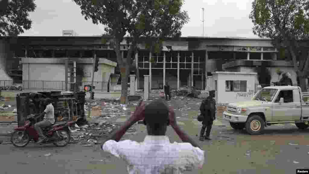 Un homme prend des photos de ce qui reste du parlement qui a été l’objet des pillages et saccages jeudi 30 octobre 2014 lors des manifestations qui ont conduit au départ du président Blaise Compaoré du pouvoir après 27 ans de règne vendredi 31 octobre 2014.