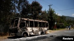 Quelques personnes passent devant un bus incendié lors des manifestations à Sebeta, dans la région d'Oromia, Ethiopie, 8 octobre 2016.