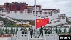 中国军人在西藏拉萨布达拉宫前升起中国国旗。（2017年7月1日）