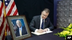 El embajador de EE.UU. en Vietnam, Daniel Kritenbrink, escribe un mensaje en el libro de condolencias por la muerte del senador estadoundiense John McCain, fallecido el sábado, 25 de agosto de 2018.