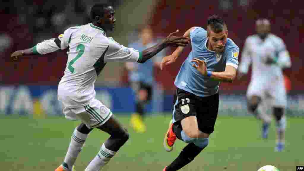 L'attaquant uruguayen Nicolas Lopez affronte le défenseur nigérian Wilfred Onyinye Ndidi lors du 16e match de football entre le Nigeria et l'Uruguay lors de la Coupe du Monde des moins de 20 ans au stade TT Arena à Istanbul le 2 juillet 2013.