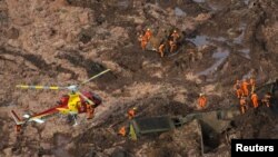 Para anggota tim SAR Brazil mencari para korban hilang pasca jebolnya sebuah bendungan di kota Brumadinho, Jumat (25/1). 