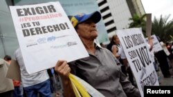 ARCHIVO - Una mujer sostiene pancartas durante una manifestación para conmemorar el Día Mundial de la Libertad de Prensa en Caracas, Venezuela, el 3 de mayo de 2016. 