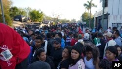Migrantes venezolanos hacen fila para recibir un boleto para una fecha de solicitud de asilo en Estados Unidos, en Matamoros, México, el jueves 22 de diciembre de 2022.