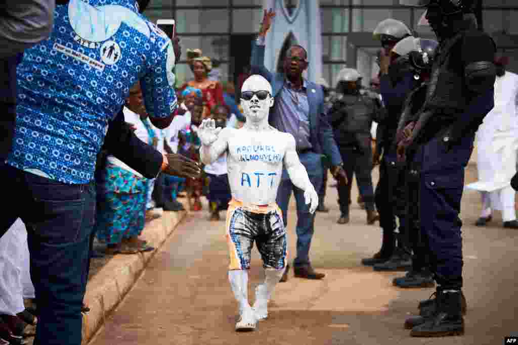 Un homme couvert de peinture blanche saluant l'arrivée de l'ancien président du Mali Amadou Toumani Touré à Bamako, le 24 décembre 2017.
