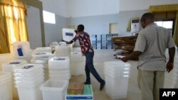 Les gens comptent les urnes et le matériel électoral reçus dans un centre de distribution de la commune de Port-Bouet à Abidjan, le 24 octobre 2015.