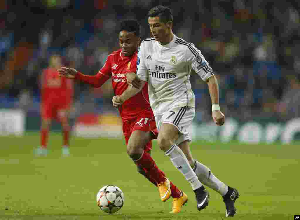 Cristiano Ronaldo du Real Madrid, à droite, se bat pour la balle avec Raheem Sterling de Liverpool lors d'un match de football, Groupe B, de la Ligue des Champions entre le Real Madrid et Liverpool au stade Santiago Bernabeu à Madrid, Espagne, le mardi 4 novembre 2014.