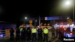 Soldados y policías vigilan en el Puente Internacional Rumichaca entre Colombia y Ecuador, luego de que el gobierno de Ecuador cerró sus fronteras a todos los viajeros extranjeros debido a la propagación de la enfermedad del coronavirus, en Tulcán, Ecuador, 16 de marzo de 2020.