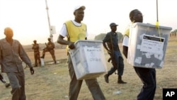 Des responsables électoraux transportant les urnes à la fermeture de leur bureau de vote à Juba
