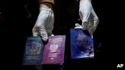 Seorang pria menunjukkan paspor Inggris, Polandia, dan Australia yang berlumuran darah setelah serangan udara Israel, di Deir al-Balah, Jalur Gaza, 1 April 2024. (Foto: AP)