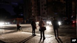 Personas esperan un transporte público en una calle durante un apagón en Caracas, Venezuela. Julio 22 de 2019.